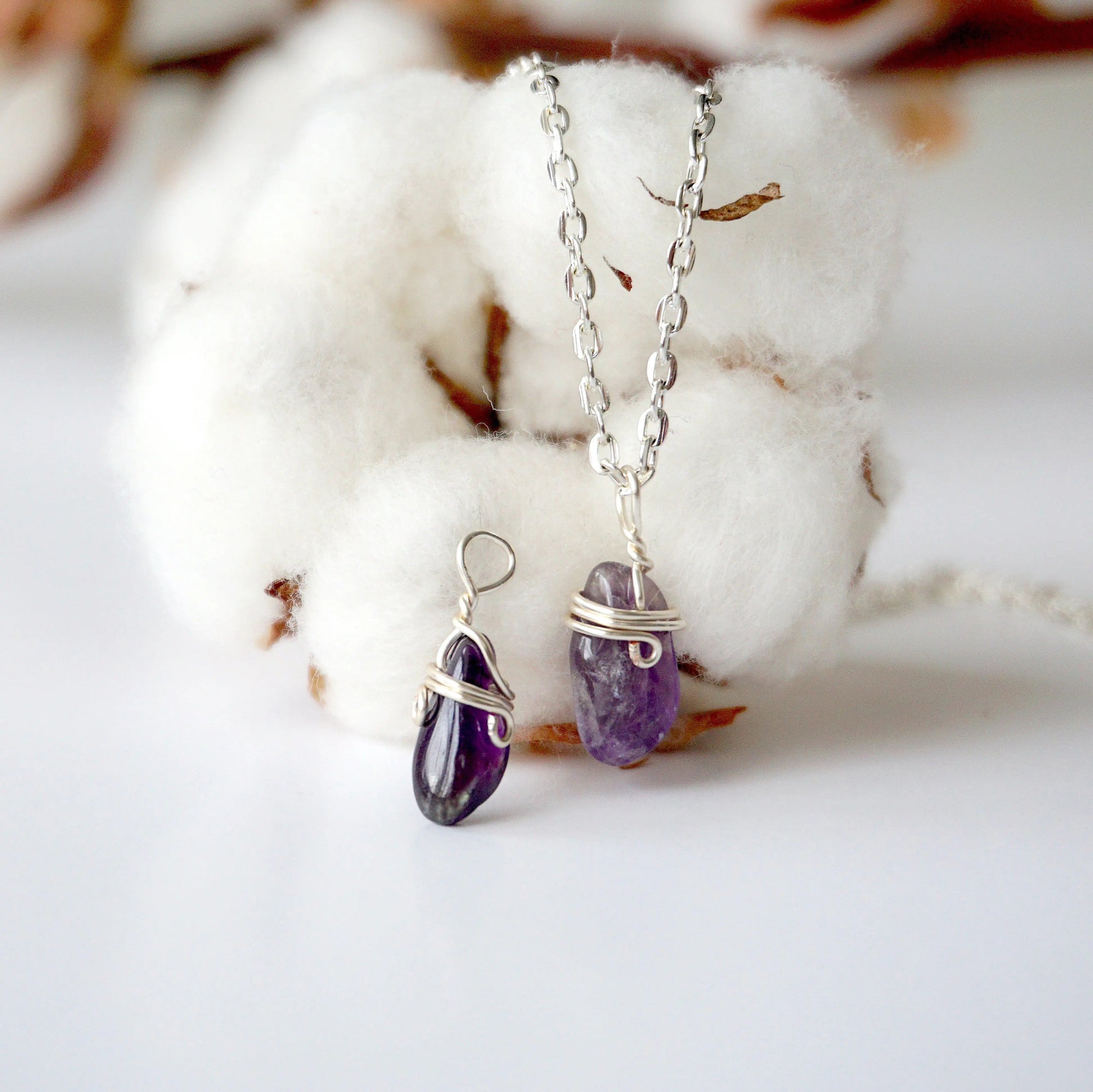 Two minimalist amethyst necklaces showing natural variation in raw amethyst pendant size, shape, and color, silver plated copper wire wrap