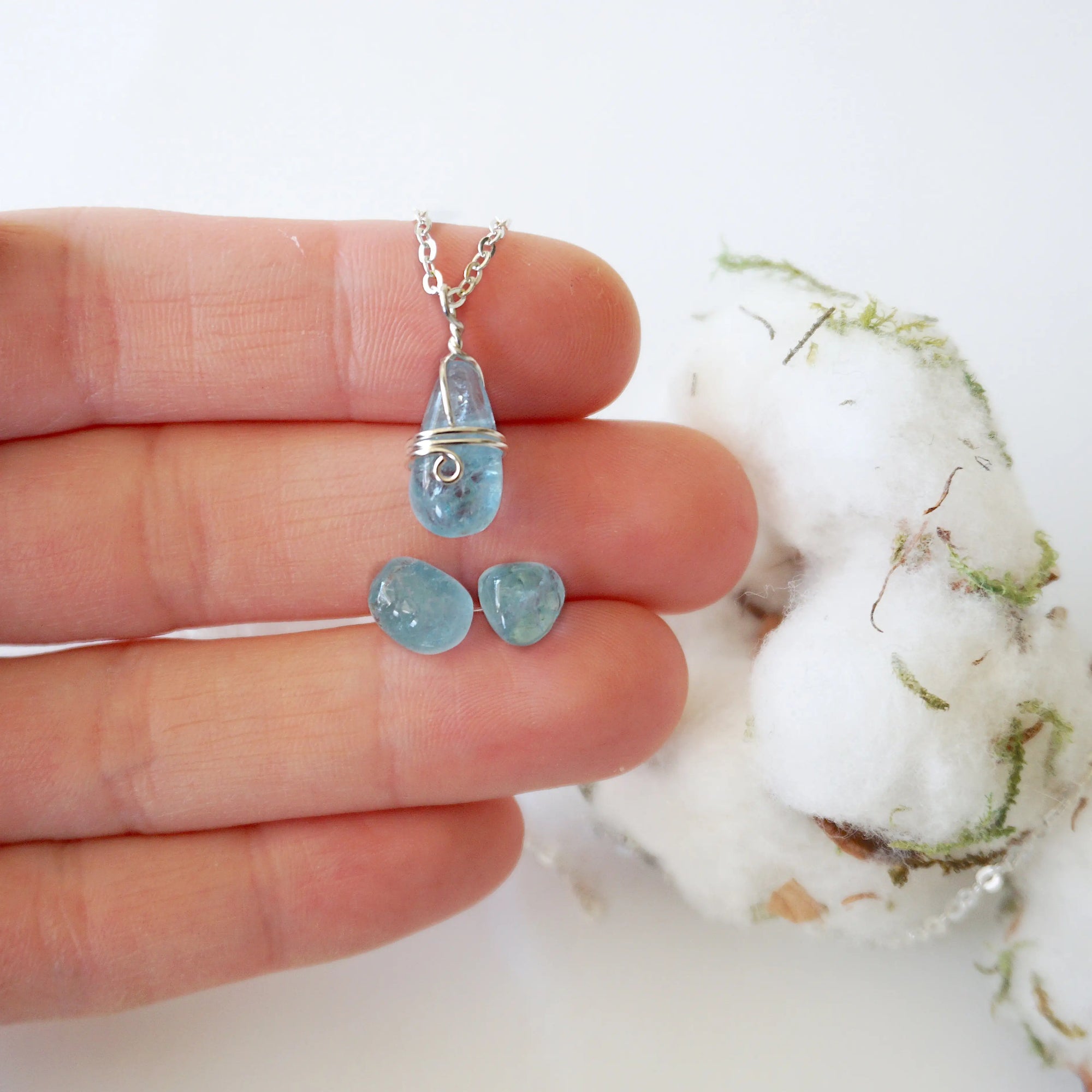 Minimalist aquamarine jewelry set with necklace and stud earrings in a hand for size reference, genuine polished aquamarine, Designs by Nature Gems