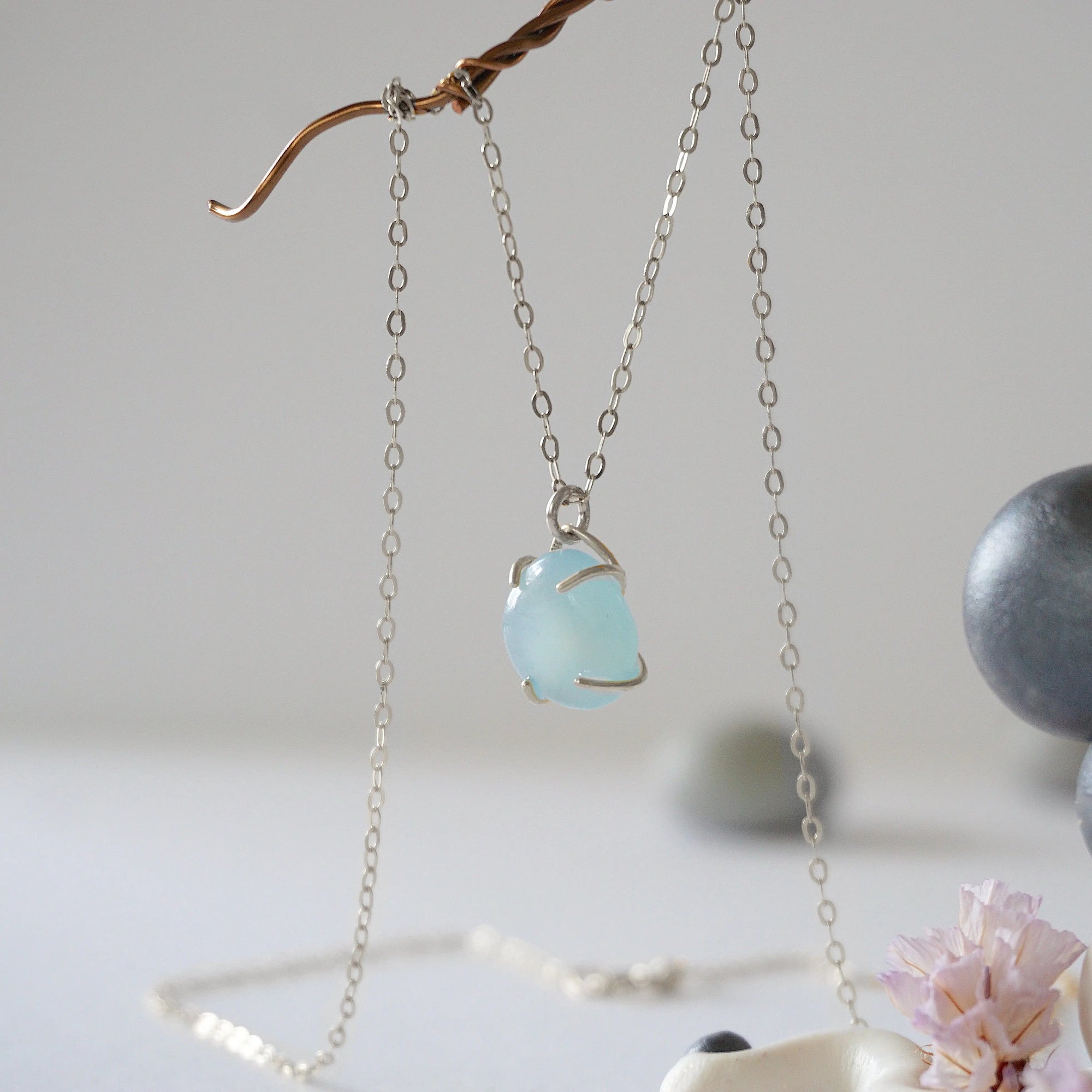 Side angle of minimalist aquamarine necklace, showing polished gemstone in claw setting, 925 sterling silver