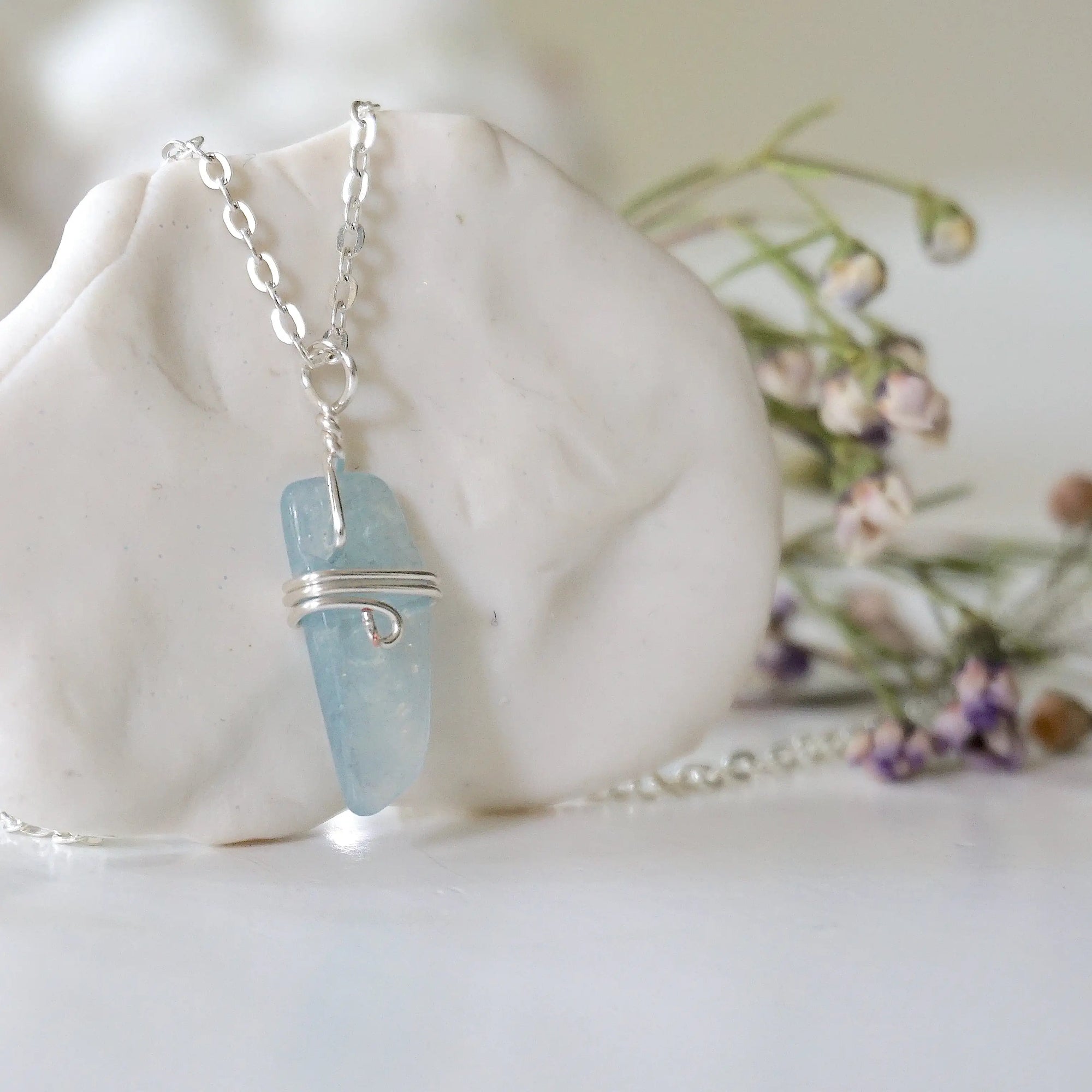 Right side angle of minimalist aquamarine necklace, showing genuine aquamarine pendant and soft silver finish over copper wire