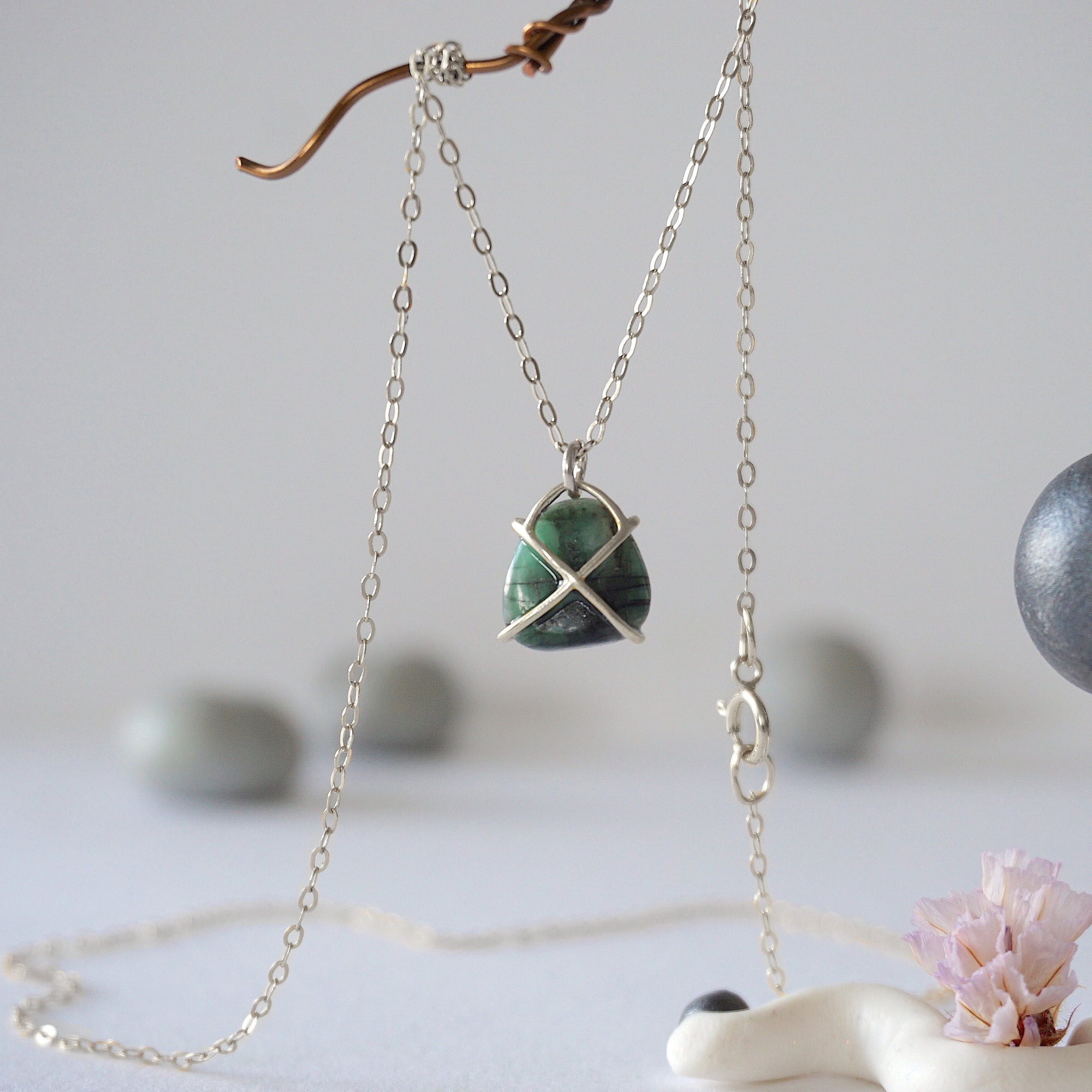 Back angle view of minimalist emerald necklace highlighting sterling silver prong setting and emerald pendant detail.