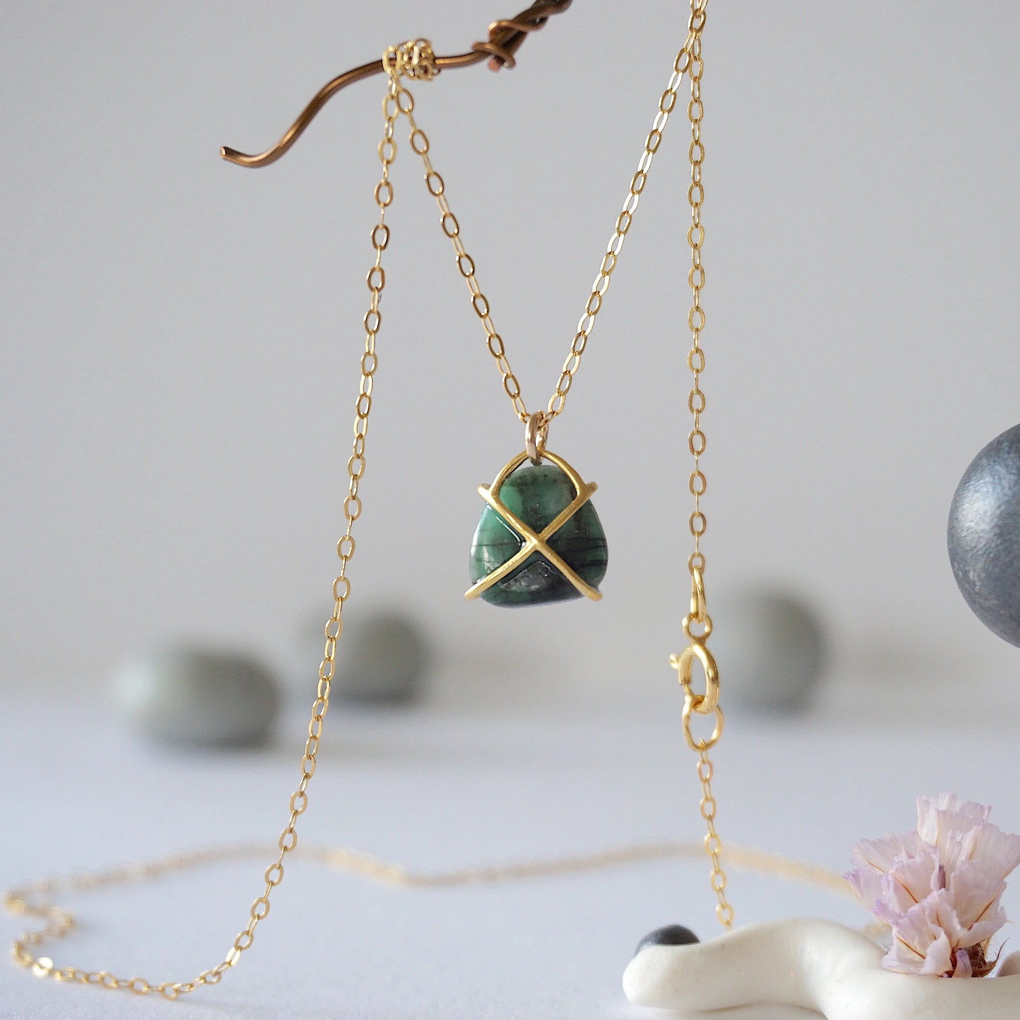 Back angle view of minimalist emerald necklace highlighting gold vermeil prong setting and emerald pendant detail.