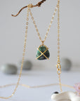 Back angle view of minimalist emerald necklace highlighting gold vermeil prong setting and emerald pendant detail.