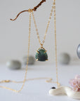 Front view of minimalist emerald necklace in gold vermeil with natural polished-raw emerald pendant for women.