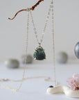 Front view of minimalist emerald necklace in 925 sterling silver with natural polished-raw emerald pendant for women.