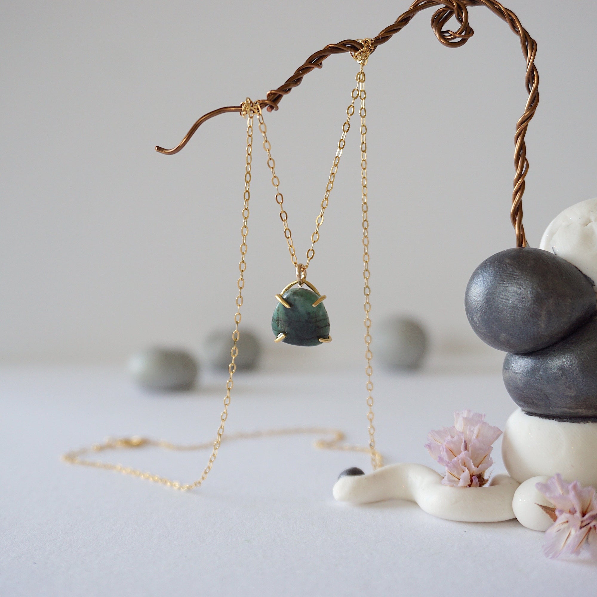 Zoomed out front view of minimalist emerald necklace in gold vermeil with natural emerald pendant.