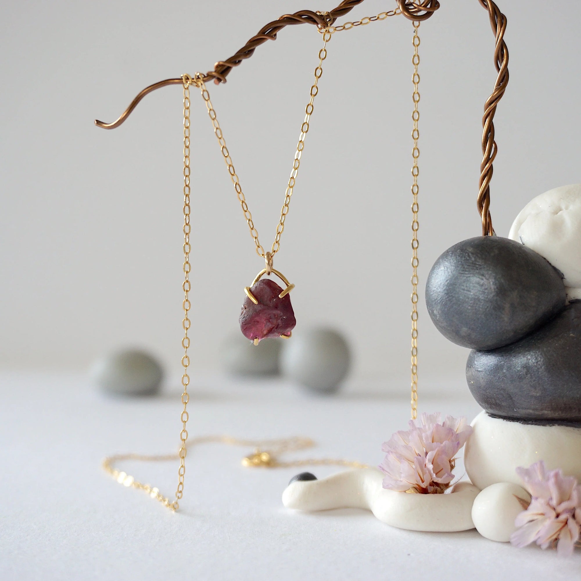 Full view of minimalist garnet necklace for women with raw garnet stone in 14k gold vermeil claw setting on 14k gold filled chain