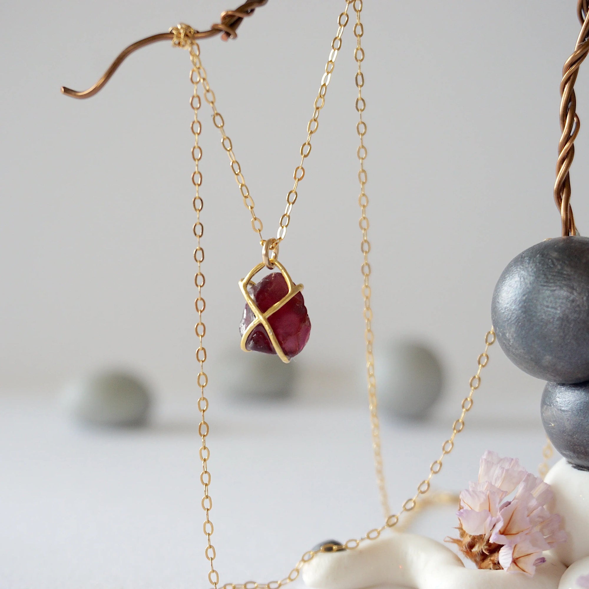 Back view of minimalist garnet pendant in 14k gold vermeil claw setting on a 14k gold filled chain