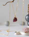 Side view of minimalist garnet pendant showing 14k gold vermeil claw setting and raw garnet texture on a 14k gold filled chain
