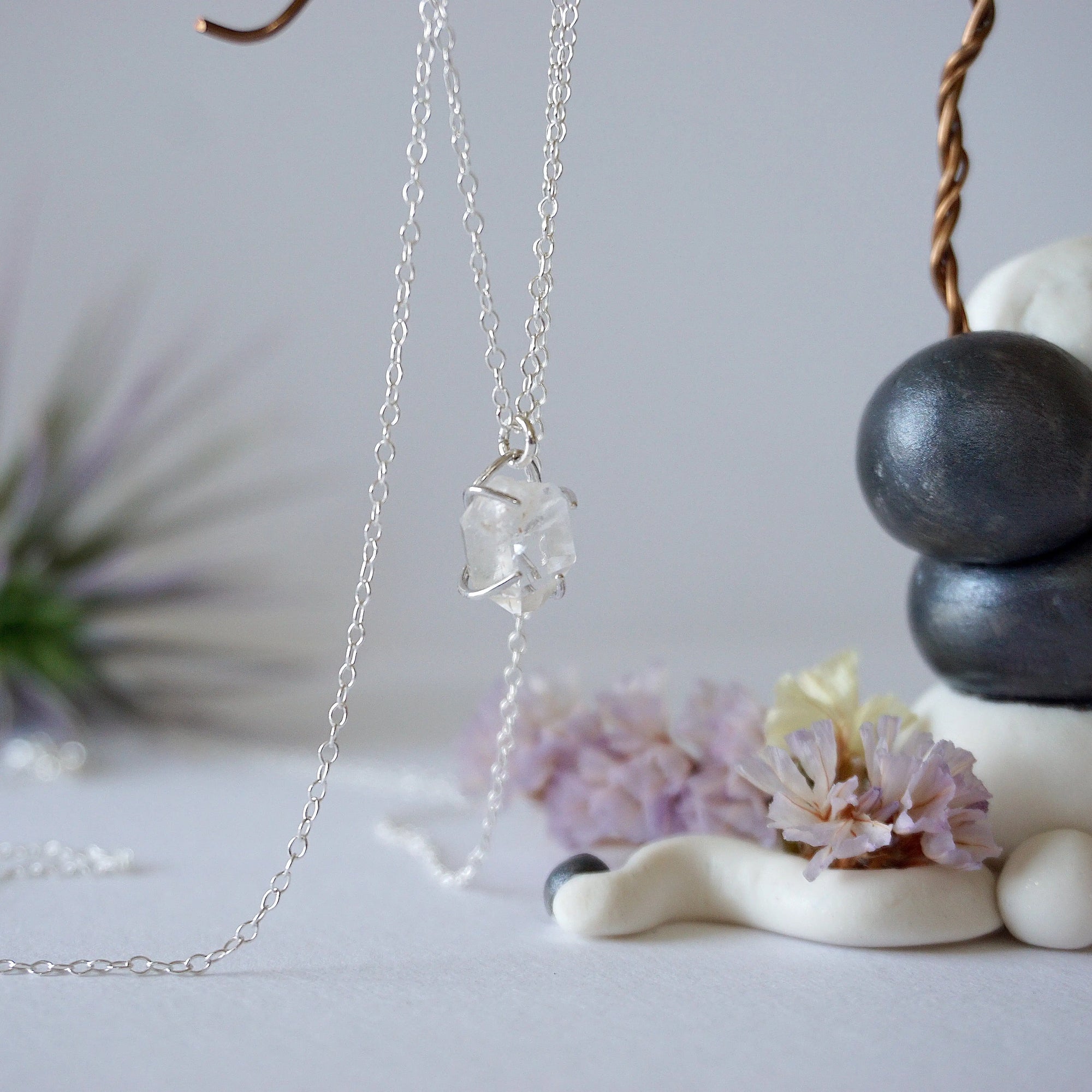 Side angle view of minimalist Herkimer diamond necklace showing 925 sterling silver prong setting detail.