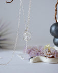 Side angle view of minimalist Herkimer diamond necklace showing 925 sterling silver prong setting detail.