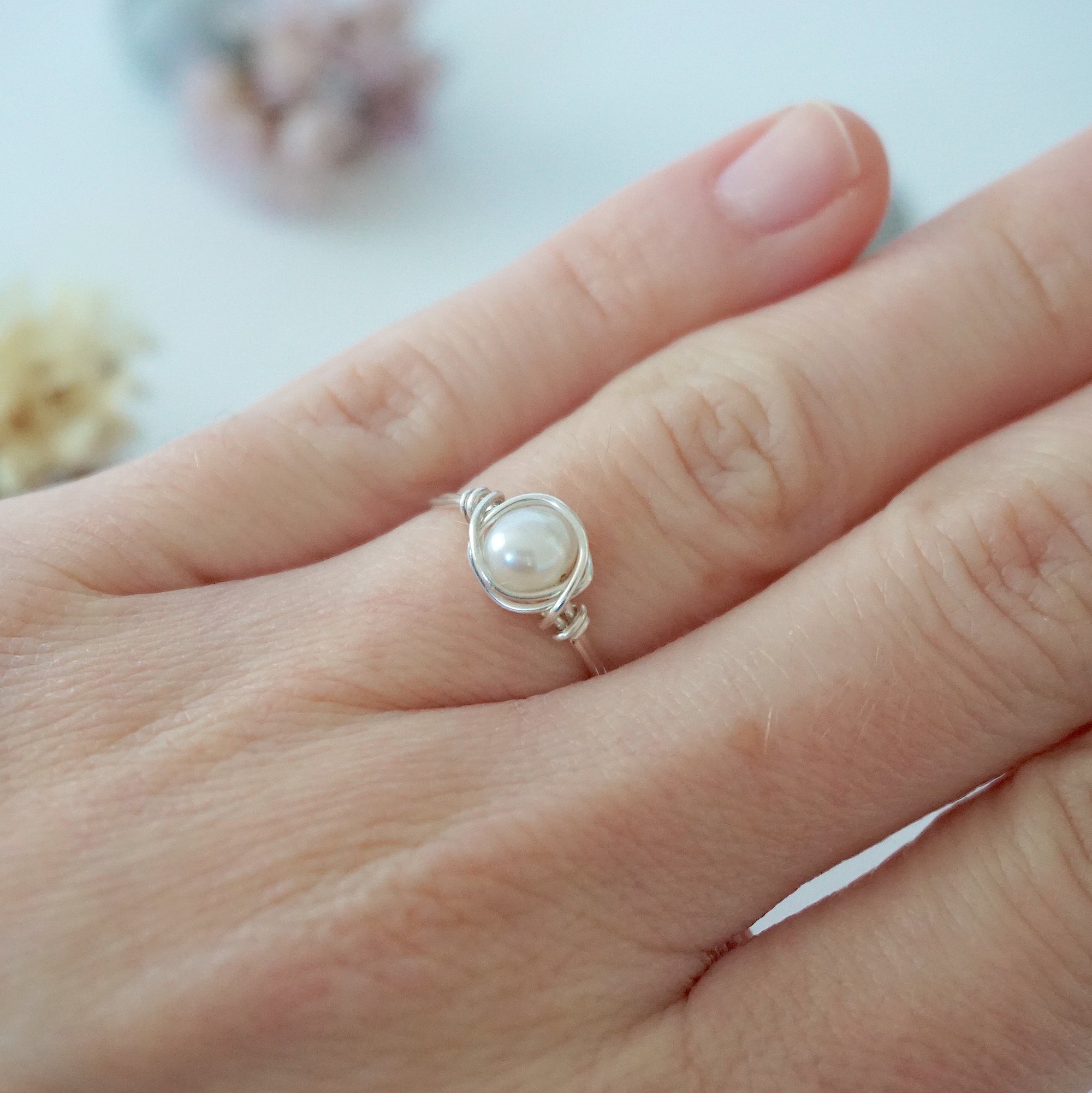Sterling silver minimalist pearl ring shown on a model’s hand for everyday wear