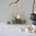 Close-up front view of minimalist rainbow moonstone necklace for women, natural raw moonstone in 14k gold vermeil prong setting on gold filled chain (June birthstone).