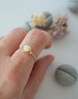 Minimalist rainbow moonstone ring for women in warm gold wire wrap on hand, dainty June birthstone ring.