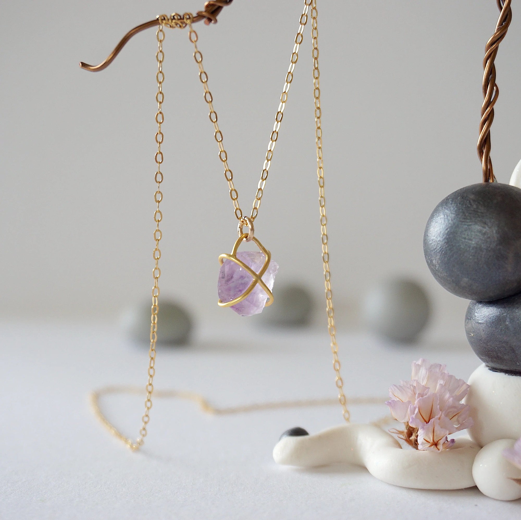 Back view of gold vermeil claw setting holding natural raw amethyst stone on minimalist February birthstone necklace