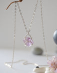 Front view of minimalist raw amethyst necklace in 925 sterling silver claw setting, February birthstone crystal pendant