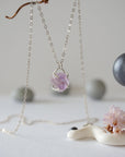 Side view of raw amethyst crystal pendant necklace in 925 sterling silver claw setting on sterling silver cable chain