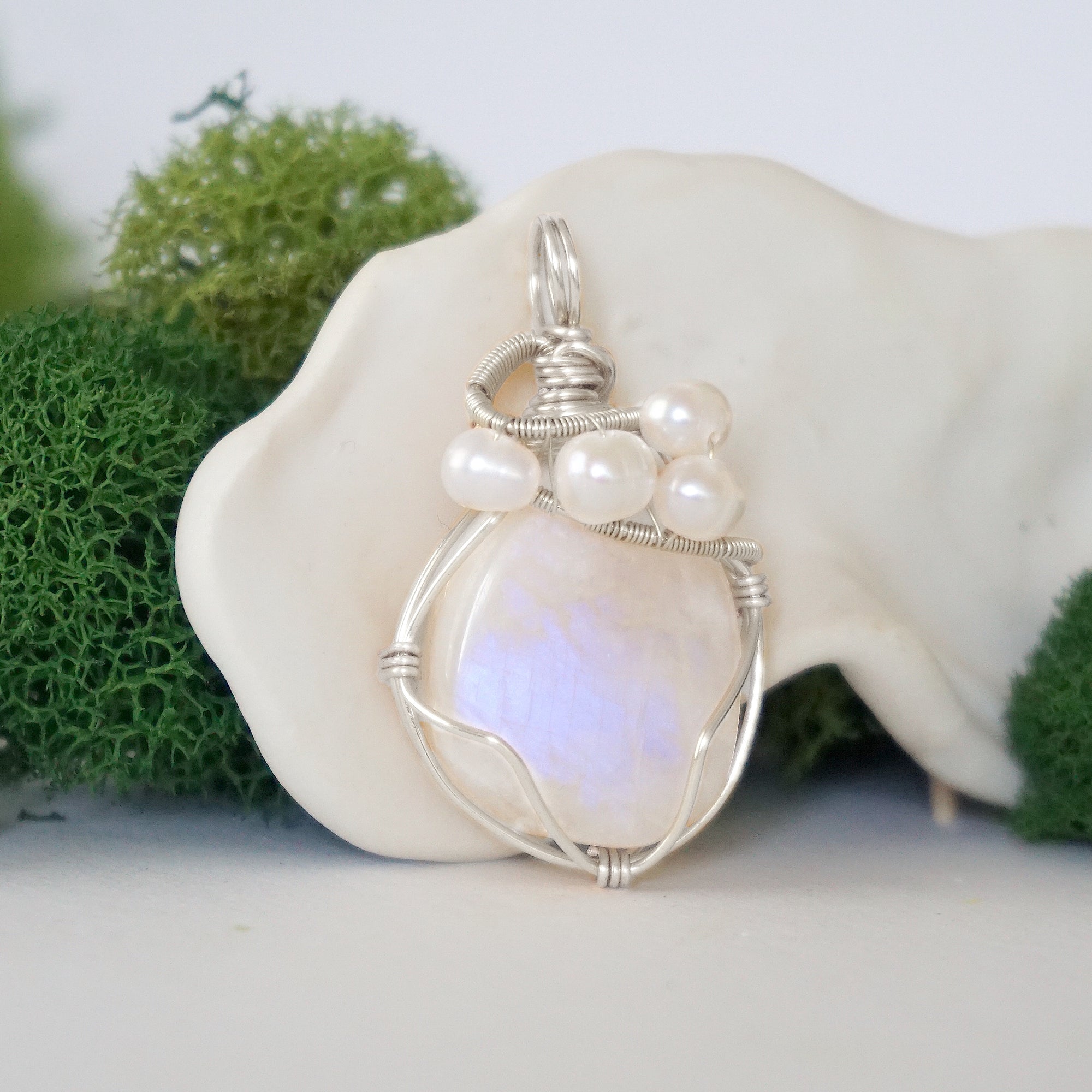 Side angle of handmade moonstone and freshwater pearl pendant necklace, silver wire wrapped jewelry