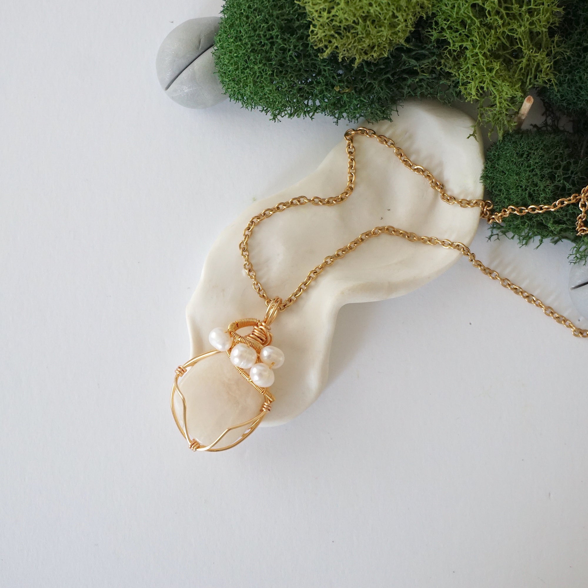 Moonstone and freshwater pearl pendant on gold plated brass chain laying flat, handmade wire wrapped jewelry for women