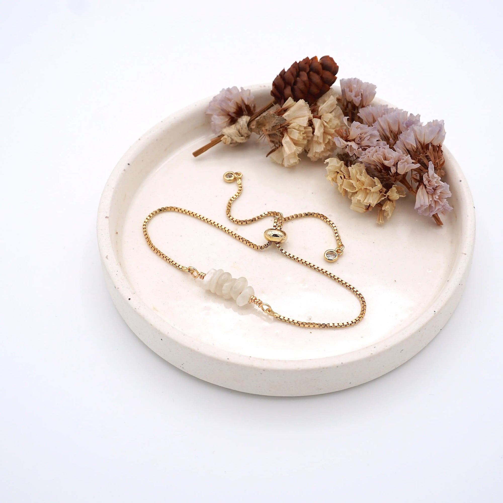 Handmade moonstone bracelet displayed on ceramic tray showing natural iridescent crystals and gold chain - June birthstone gift for her