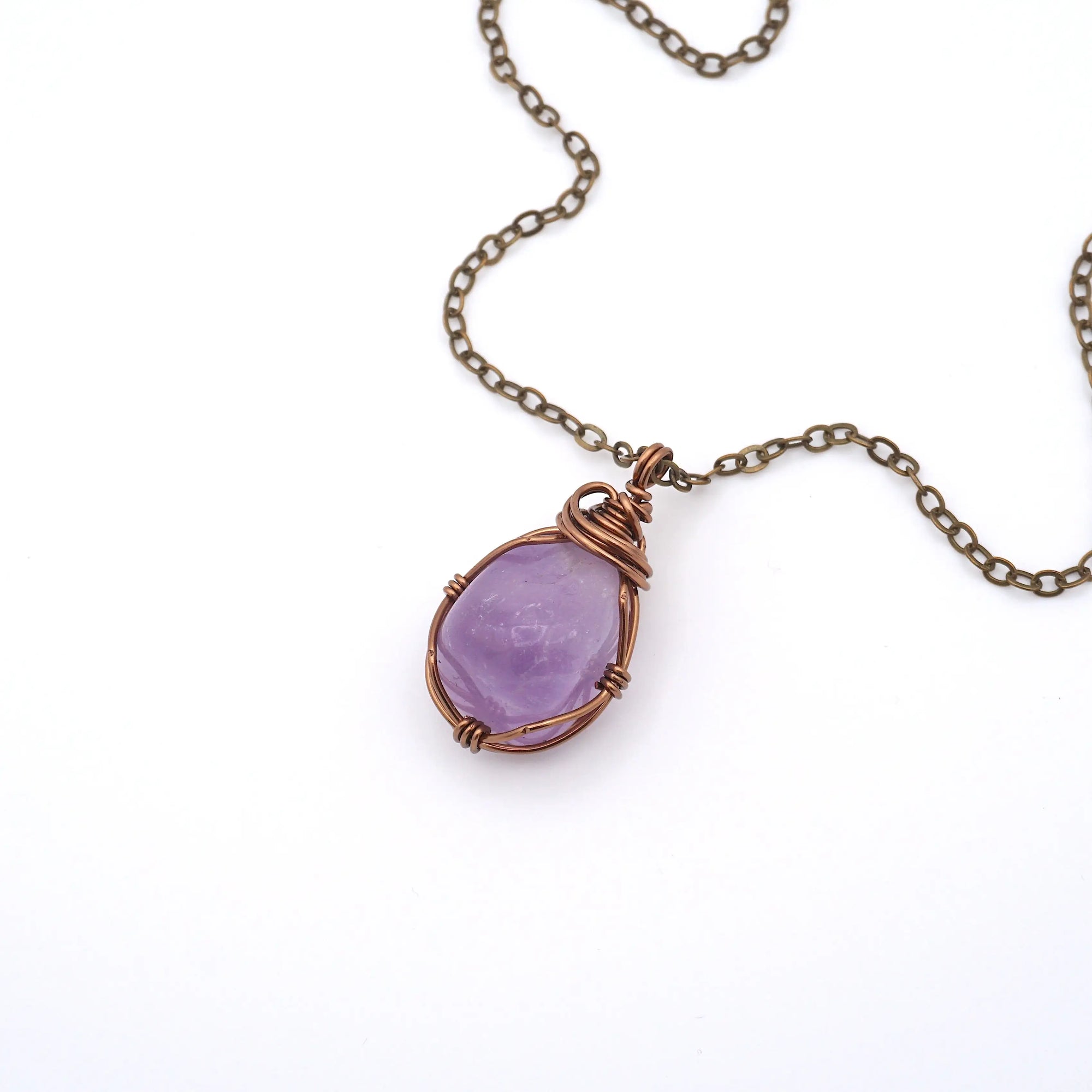 Natural amethyst wire wrapped pendant necklace on antique bronze chain, flat lay product photo