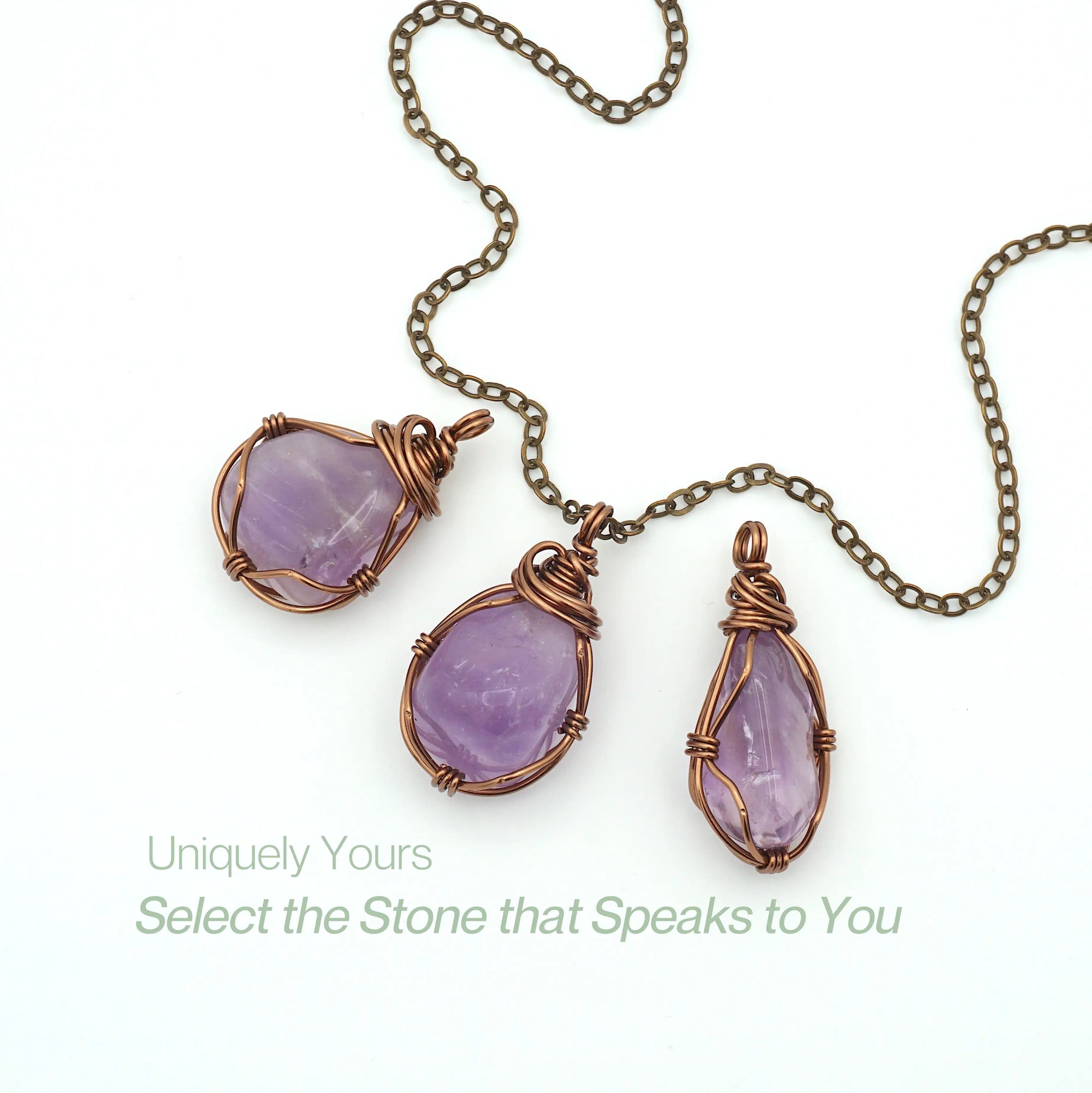 Three natural amethyst wire wrapped pendants on antique bronze chain showing stone color and shape variation