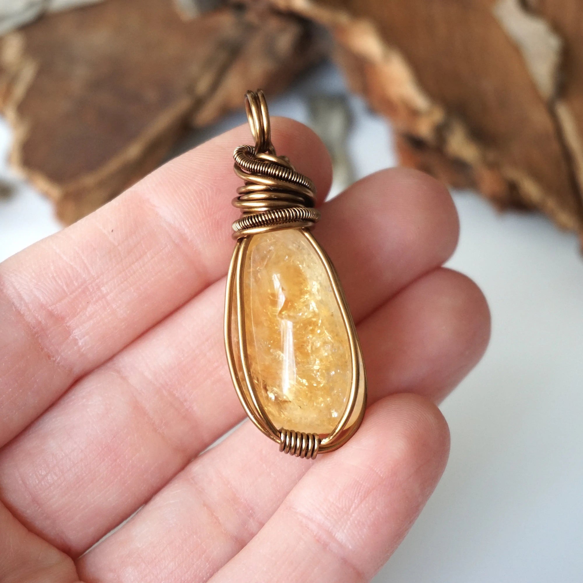 Natural citrine pendant held in hand showing size scale - wire wrapped crystal in antique bronze copper handmade unisex necklace size reference for women men