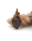 Back angle of raw garnet pendant showing wire wrapping and natural crystal texture