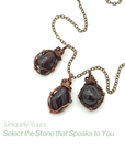 Three different raw garnet pendants on one antique bronze copper chain showing natural stone variation