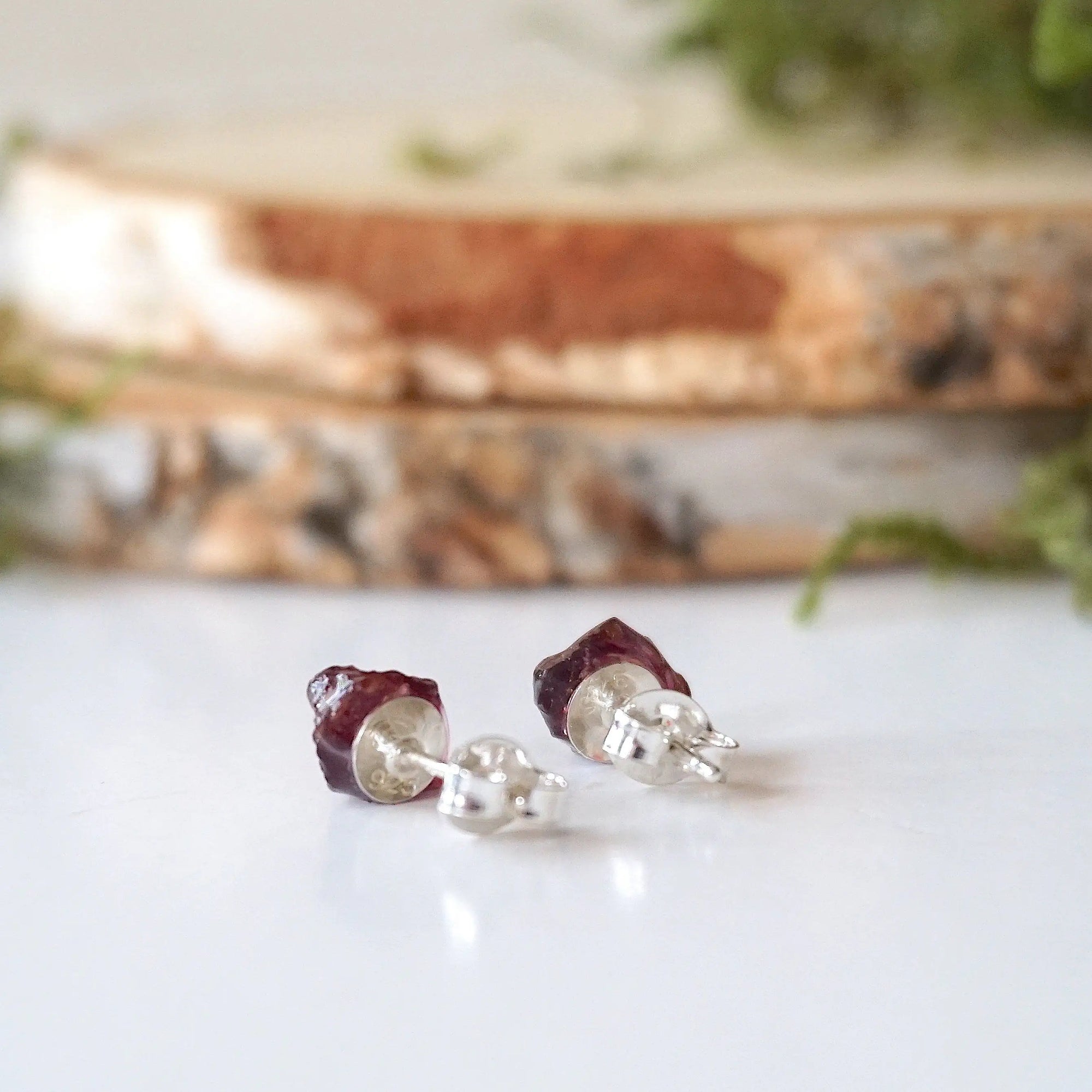 Back detail of garnet stud earrings showing 925 sterling silver posts and backs, hypoallergenic minimalist earrings