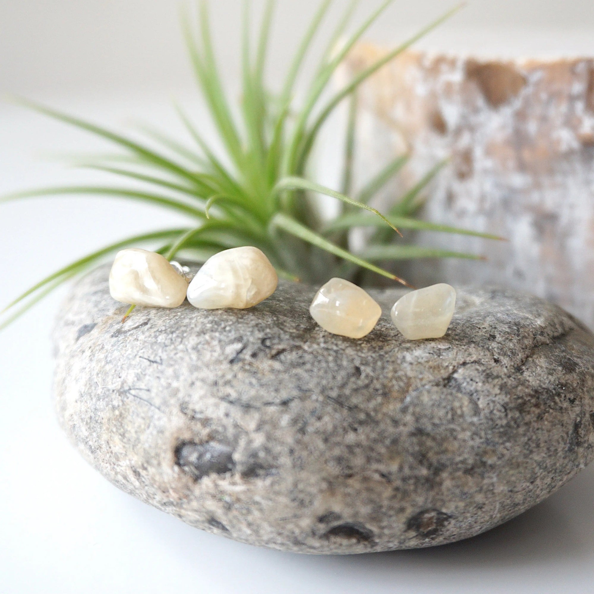Two pairs of natural moonstone stud earrings showing variation in stone size, shape, and colour shade on 925 sterling silver posts.