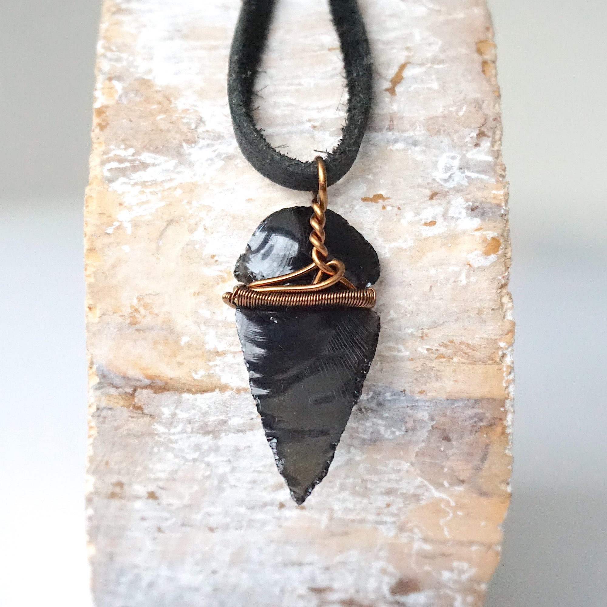 Back view of black obsidian arrowhead pendant with antique bronze copper wire wrap, handcrafted men’s necklace by Designs by Nature Gems.