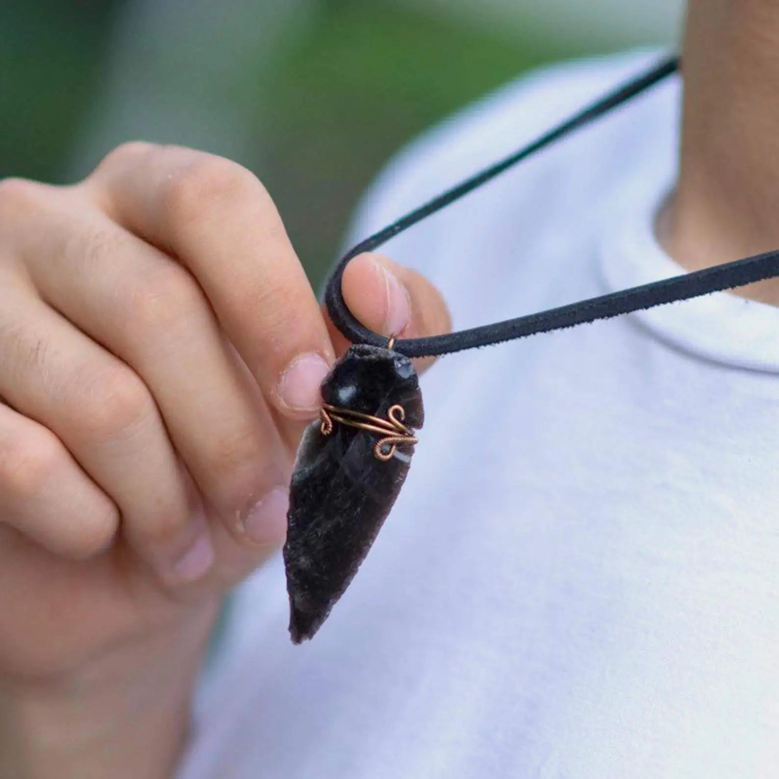 Men’s black obsidian arrowhead necklace with antique bronze copper wire wrap on male model, handcrafted by Designs by Nature Gems.