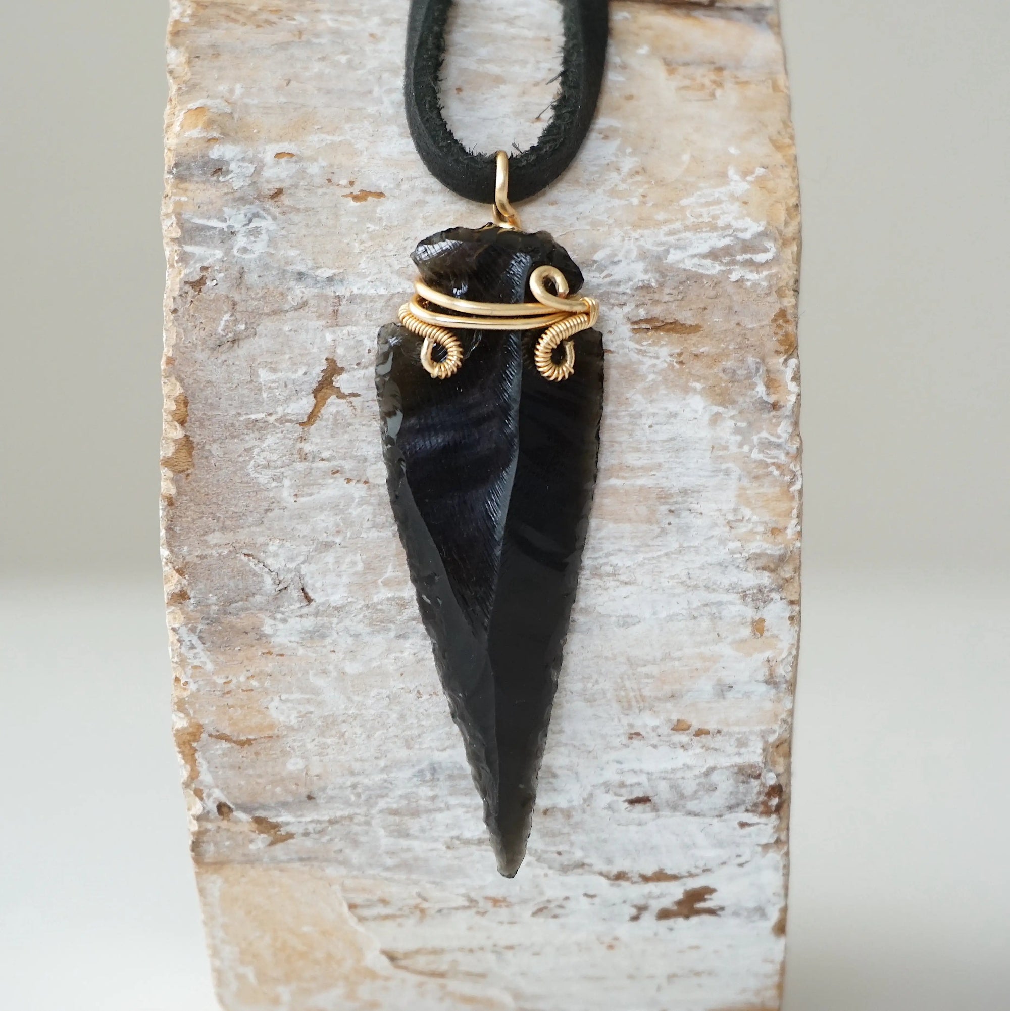 Detailed front view of men’s black obsidian arrowhead necklace on black leather cord, gold plated copper wire wrap, by Designs by Nature Gems.