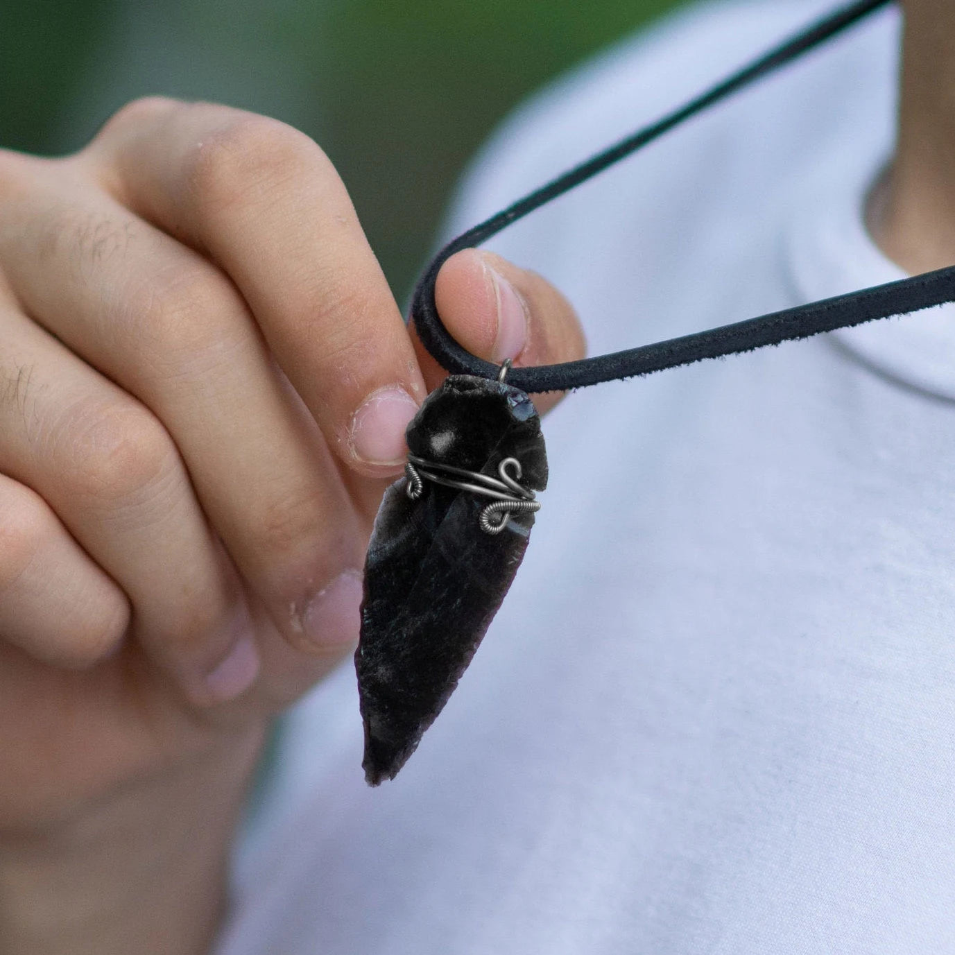 Men’s black obsidian arrowhead necklace on male model, artisan wire wrapped pendant, handcrafted by Designs by Nature Gems.