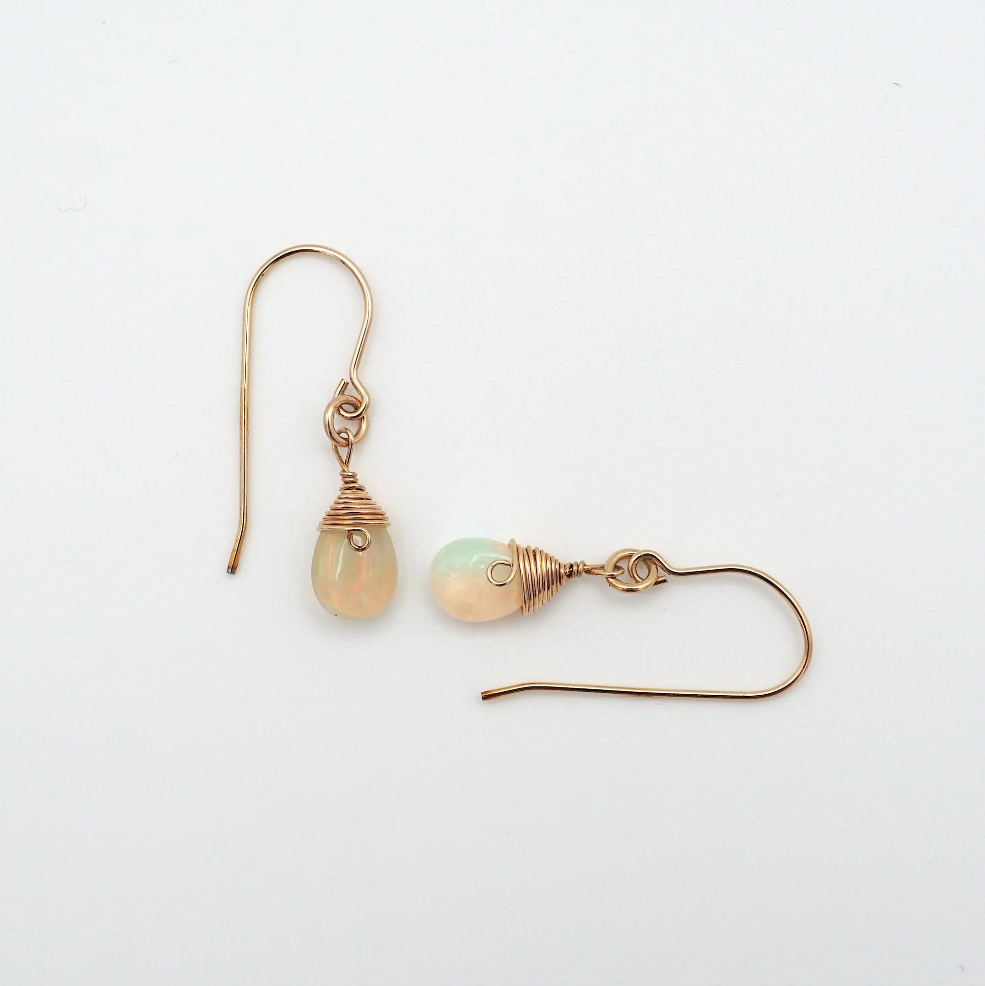 Closeup showing details of opal drop earrings, faceted opal stone, 14k gold filled setting