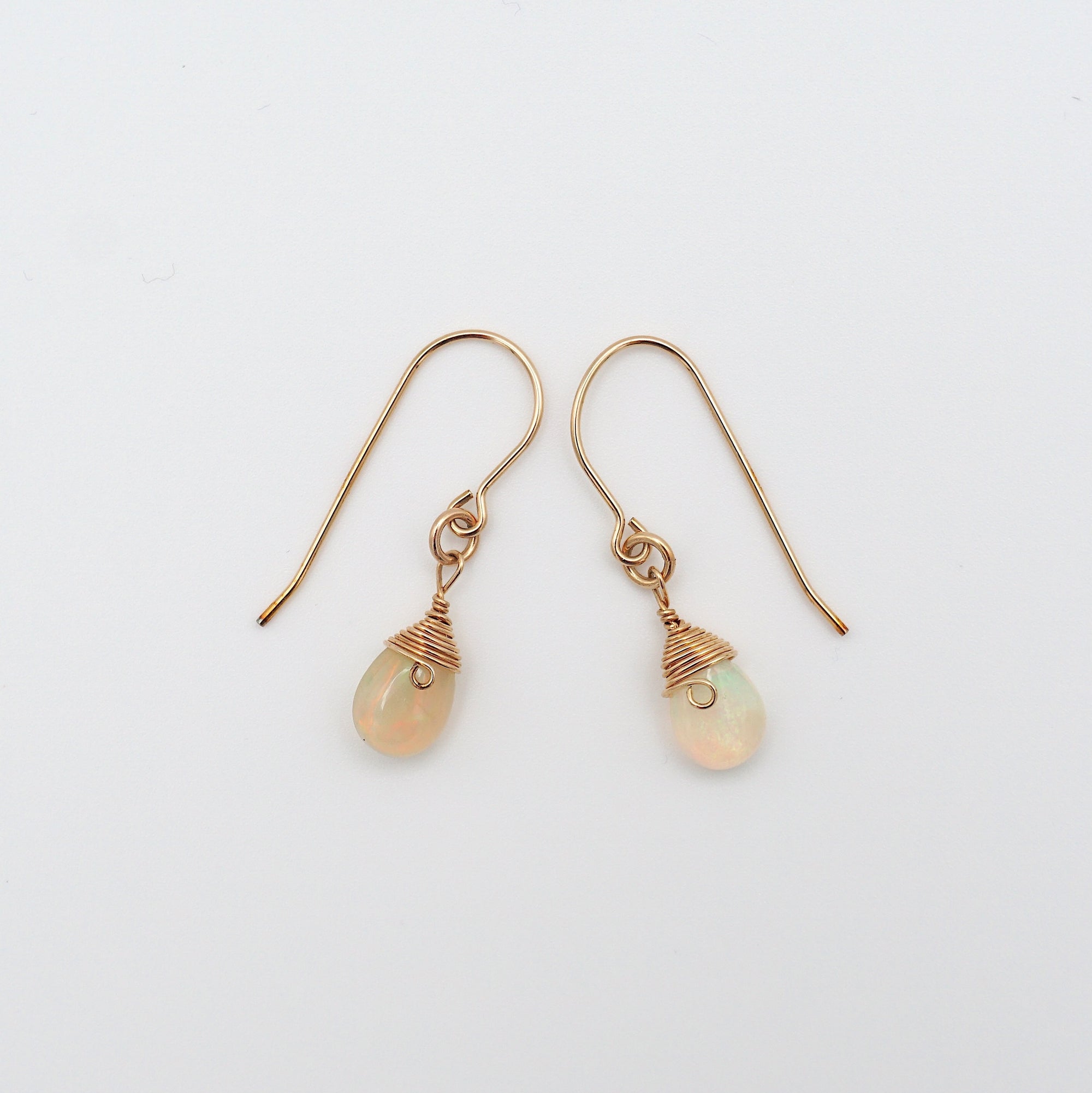 Side angle of opal drop earrings, minimalist artisan wire wrapping, 14k gold filled