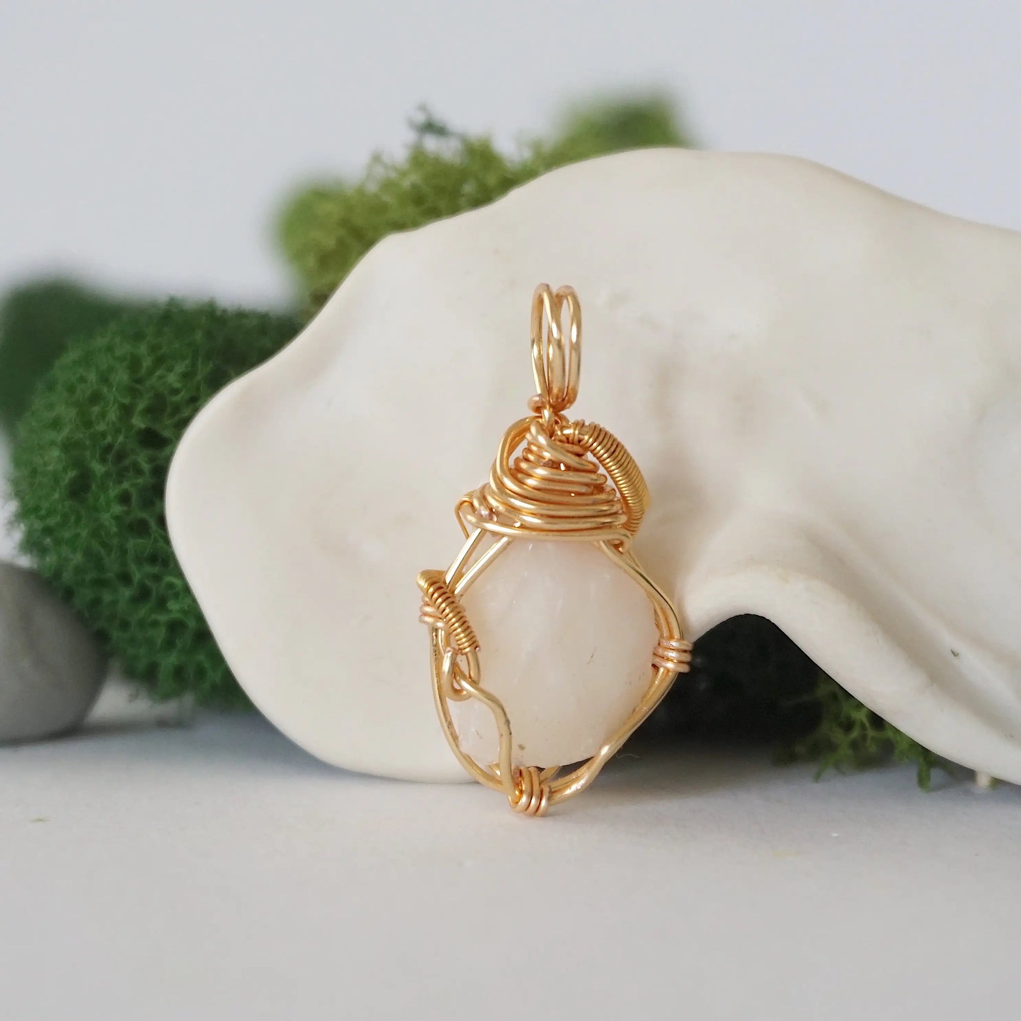 Back angle detail of opal and freshwater pearl pendant, showing wire wrapping and natural stone