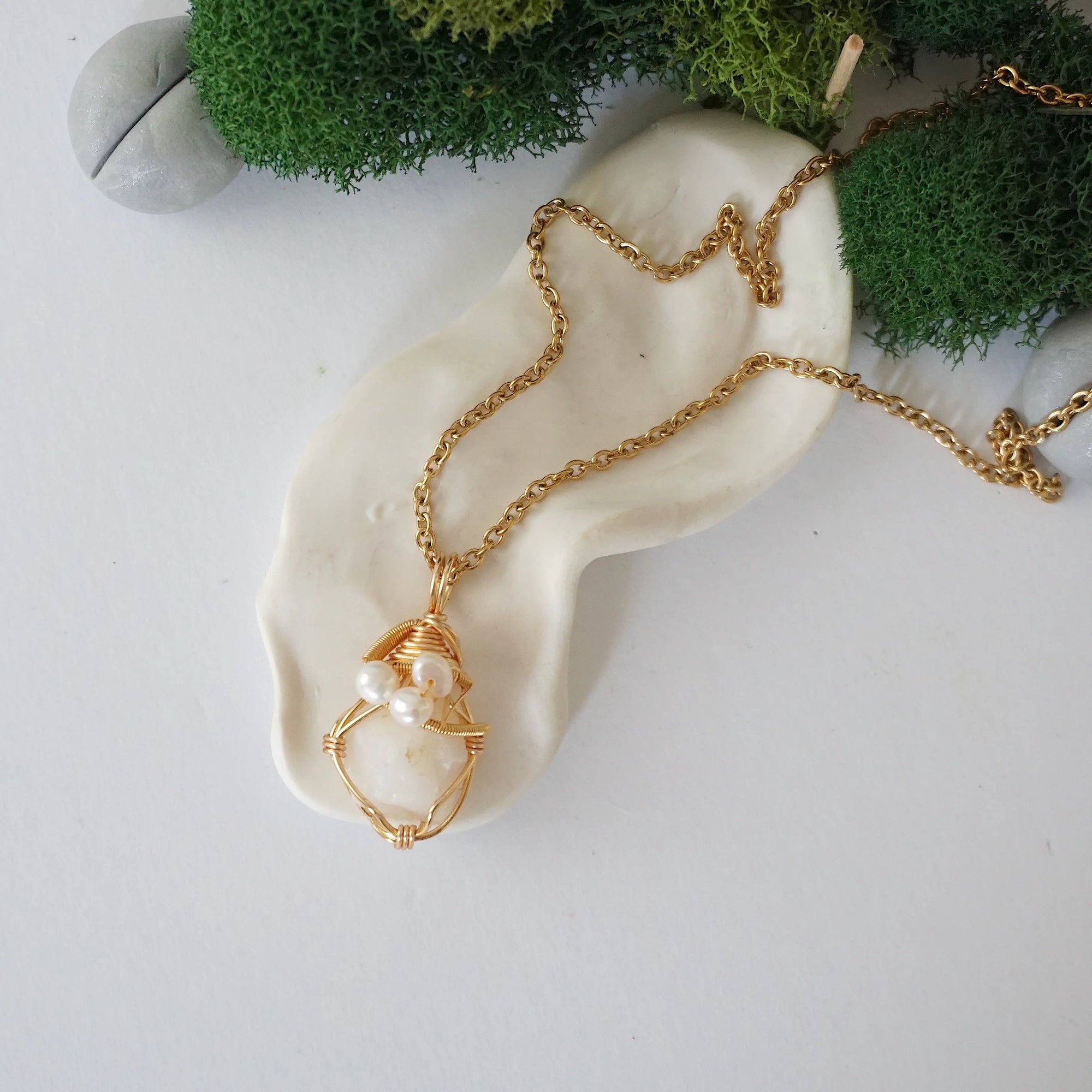 Opal and freshwater pearl pendant on gold plated brass chain laying flat, handmade wire wrapped jewelry for women