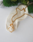 Opal and freshwater pearl pendant on gold plated brass chain laying flat, handmade wire wrapped jewelry for women