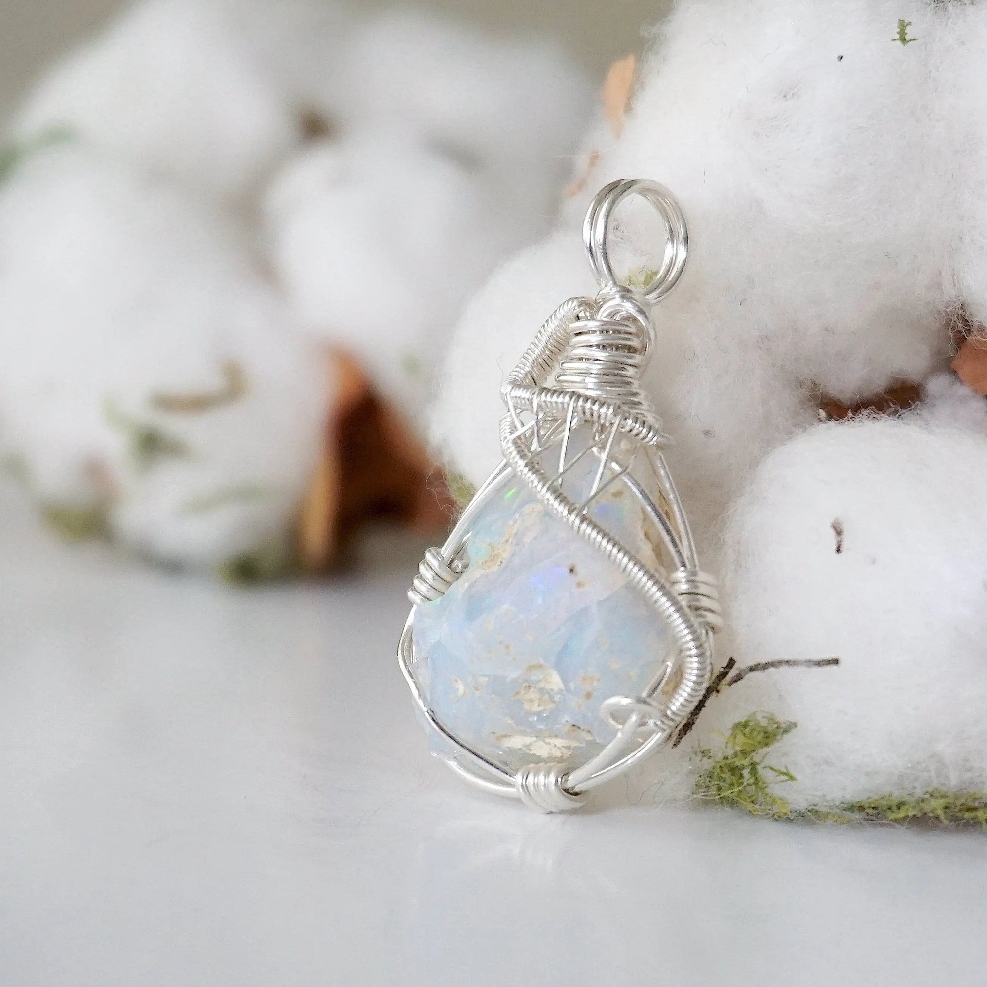 Left side angle detail of sterling silver opal pendant, artisan wire wrapped by Designs by Nature Gems.