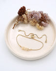 Handmade opal bracelet displayed on ceramic tray showing natural iridescent crystals and gold chain - October birthstone gift for her