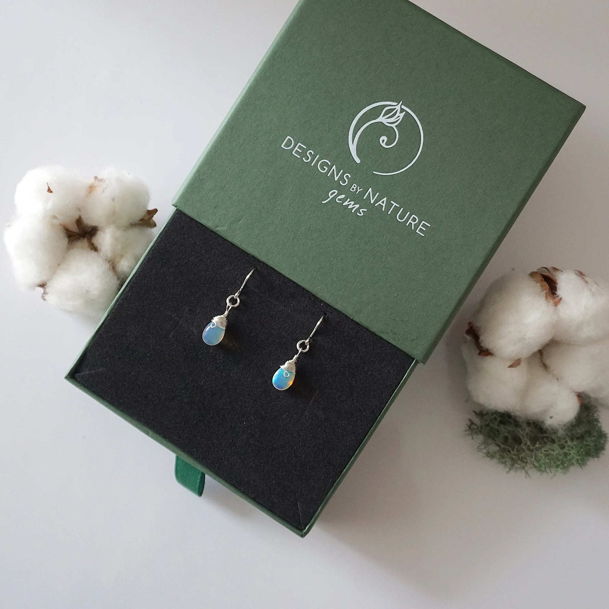 Opal sterling silver drop earrings in branded Designs by Nature Gems jewelry box, showcasing handcrafted faceted opal and sterling silver wire wrapping