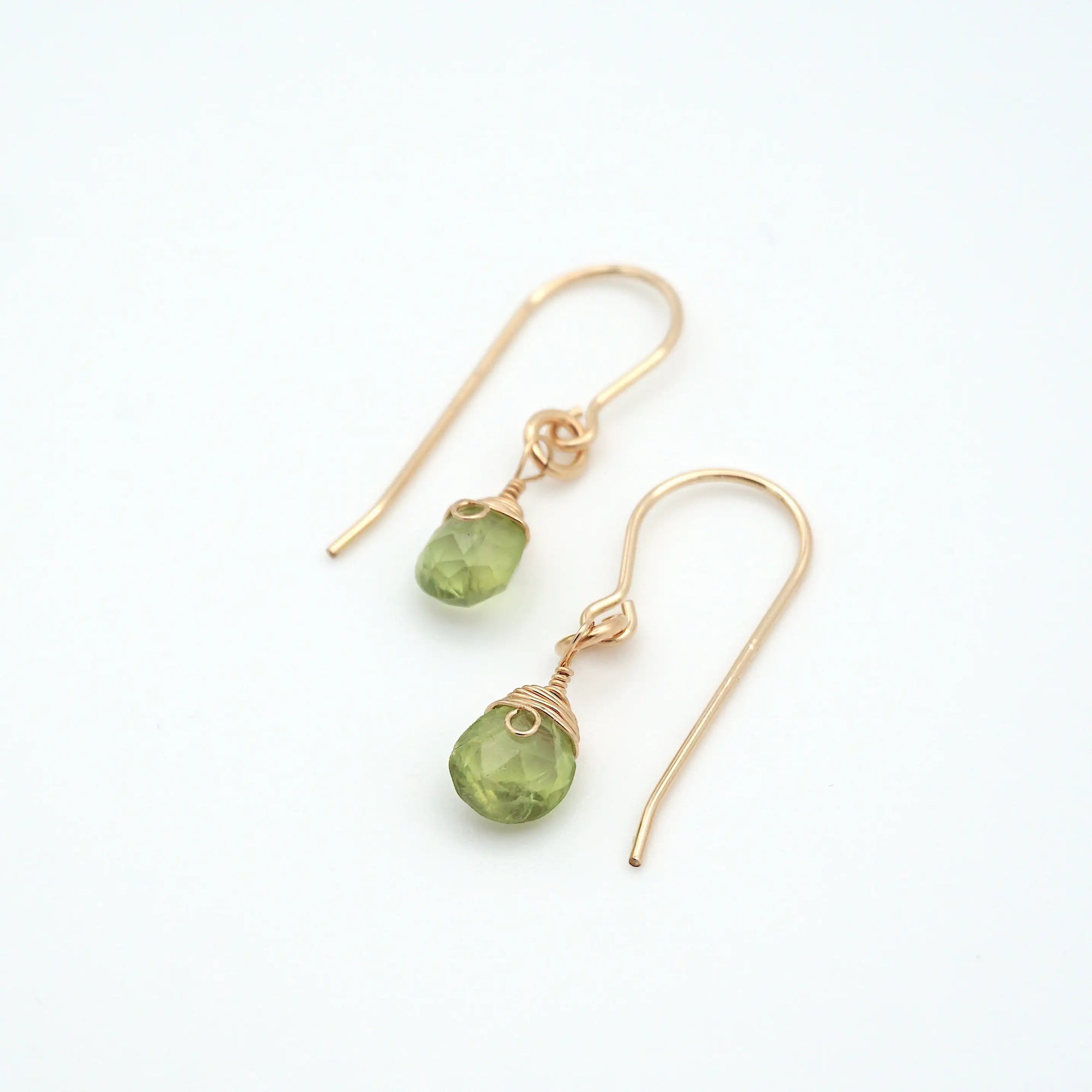 Angled look at peridot drop earrings, artisan wire wrapping in 14k gold filled, August birthstone