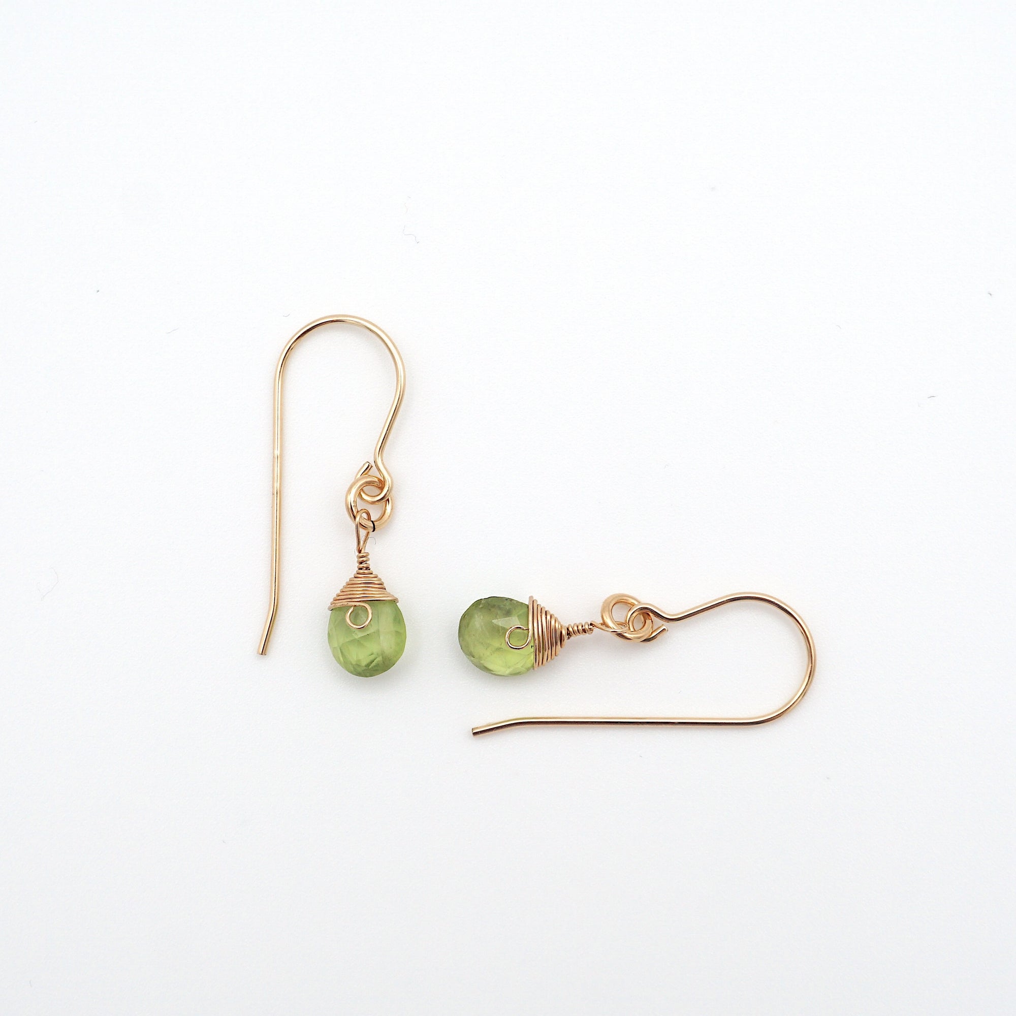 Closeup showing details of peridot drop earrings, faceted peridot stone, 14k gold filled setting