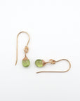 Closeup showing details of peridot drop earrings, faceted peridot stone, 14k gold filled setting