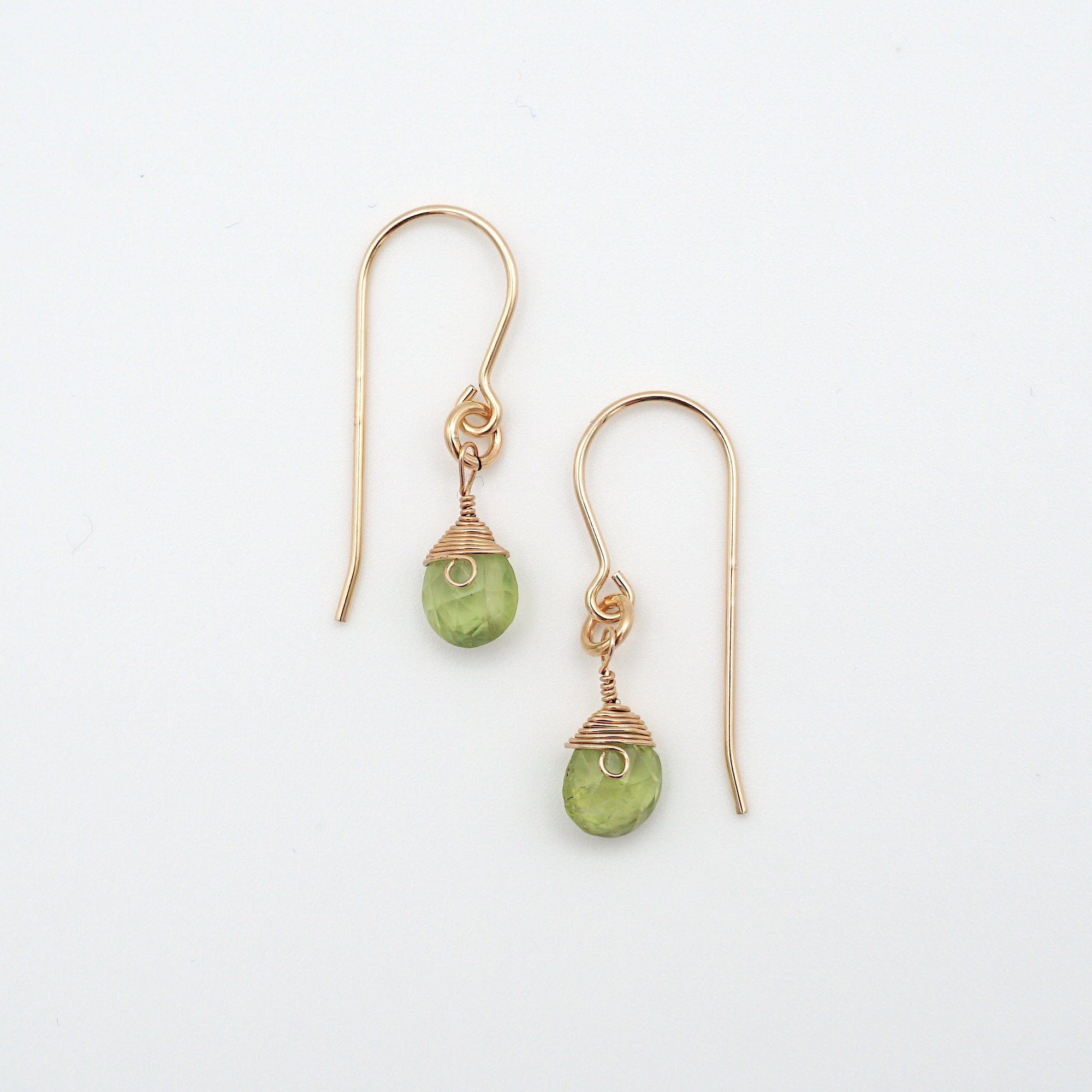 Detailed front view of peridot drop earrings, genuine faceted peridot with minimalist 14k gold filled wire wrapping, Designs by Nature Gems
