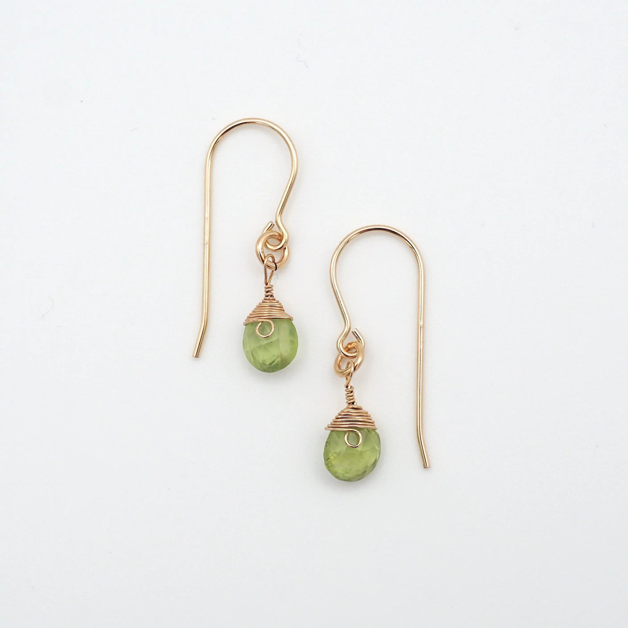 Detailed front view of peridot drop earrings, genuine faceted peridot with minimalist 14k gold filled wire wrapping, Designs by Nature Gems
