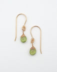 Detailed front view of peridot drop earrings, genuine faceted peridot with minimalist 14k gold filled wire wrapping, Designs by Nature Gems