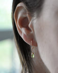 Peridot drop earrings on a female model, genuine faceted peridot, 14k gold filled